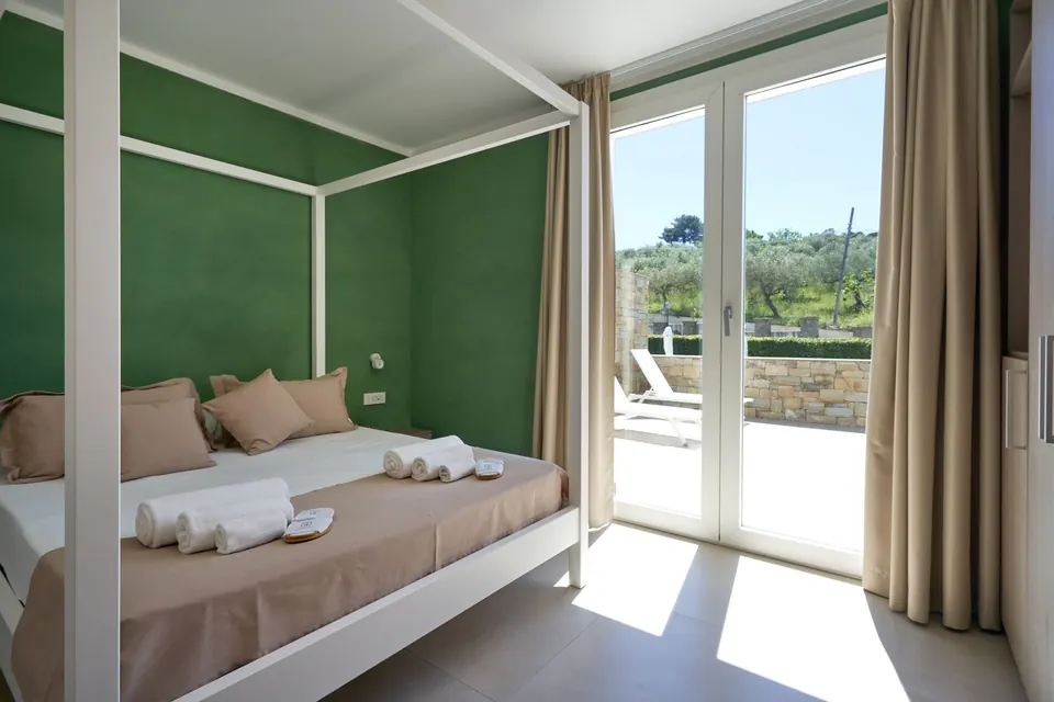 Camera matrimoniale con letto a baldacchino e porta finestra sulla terrazza