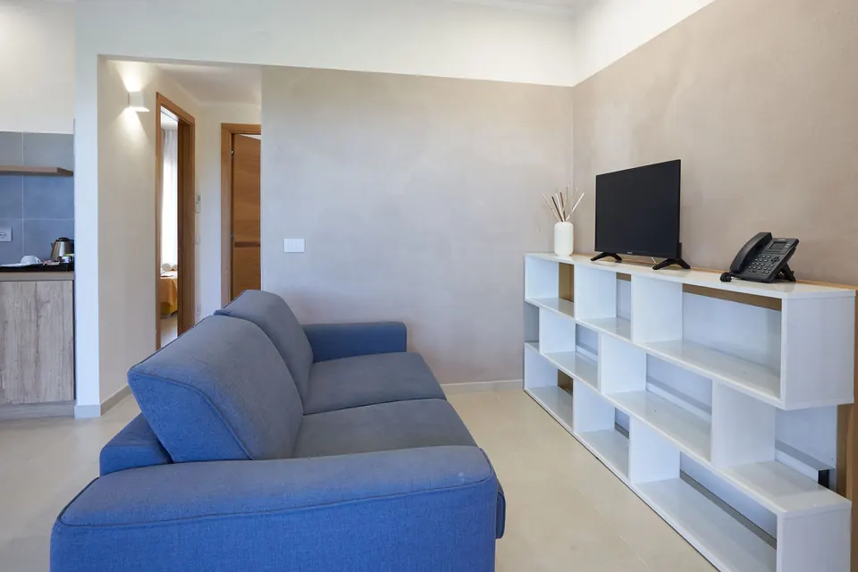 Soggiorno con divano blu e libreria bianca