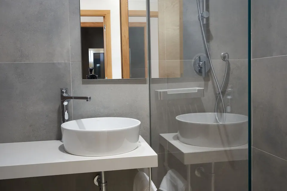 Bagno con lavabo in ceramica e doccia in vetro