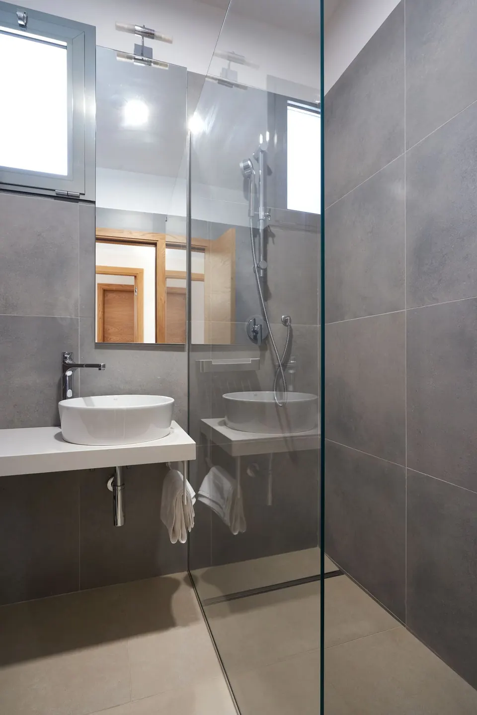 Bagno con doccia e specchio illuminato