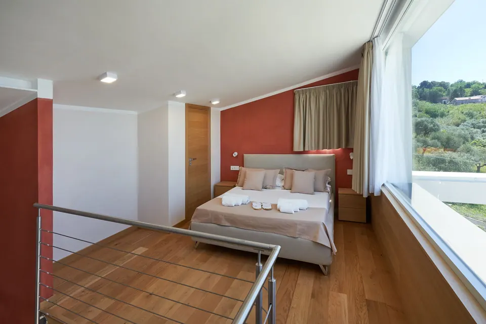 Camera da letto soppalcata con parquet e vetrata