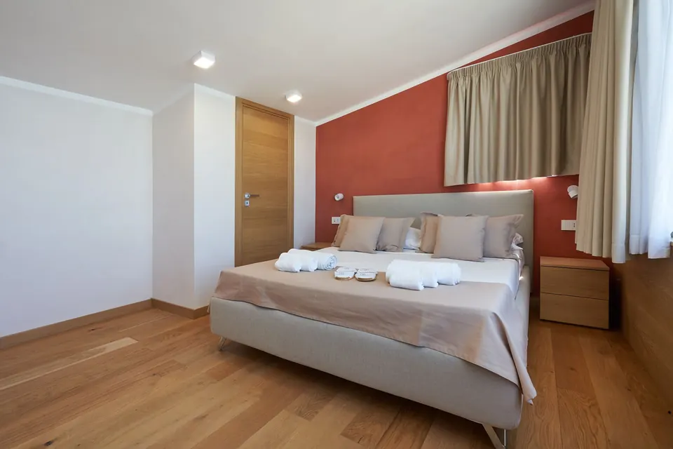 Camera da letto matrimoniale con parquet e finestra panoramica