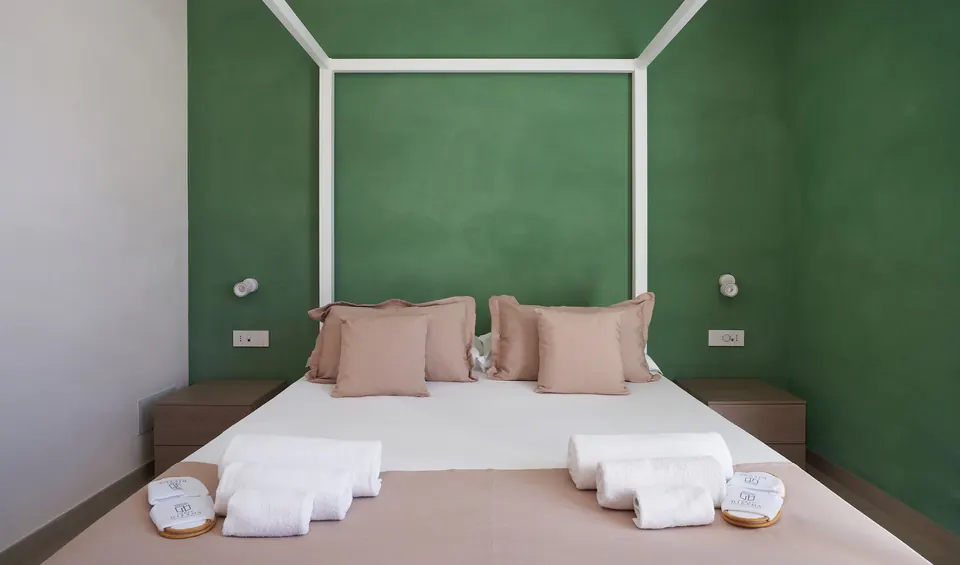 Letto matrimoniale e parete verde