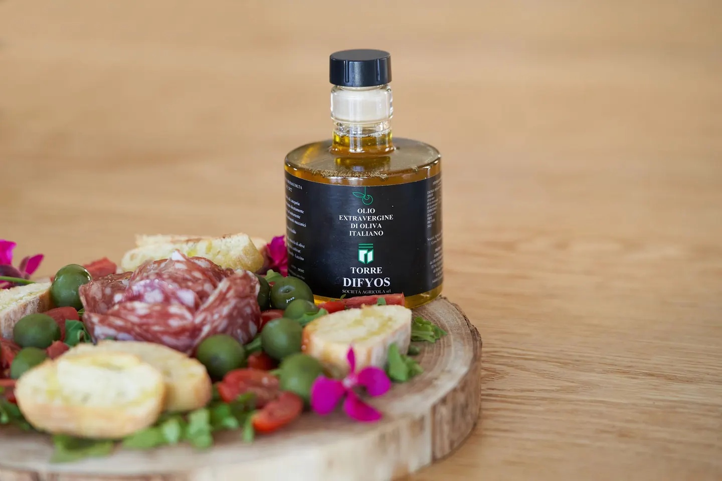 Bottiglia di olio extravergine Torre Difyos con salumi e formaggi del Cilento