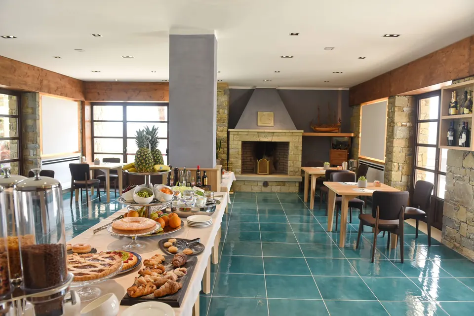Sala del ristorante con camino in pietra e tavoli apparecchiati