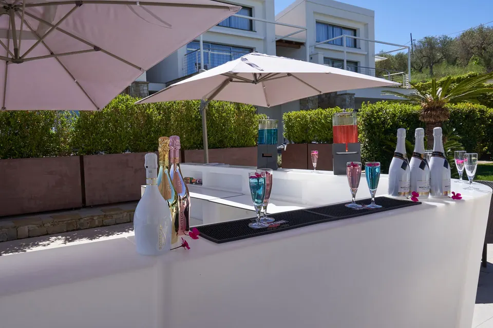 Bordo piscina con lettini, ombrelloni e il bar all'aperto