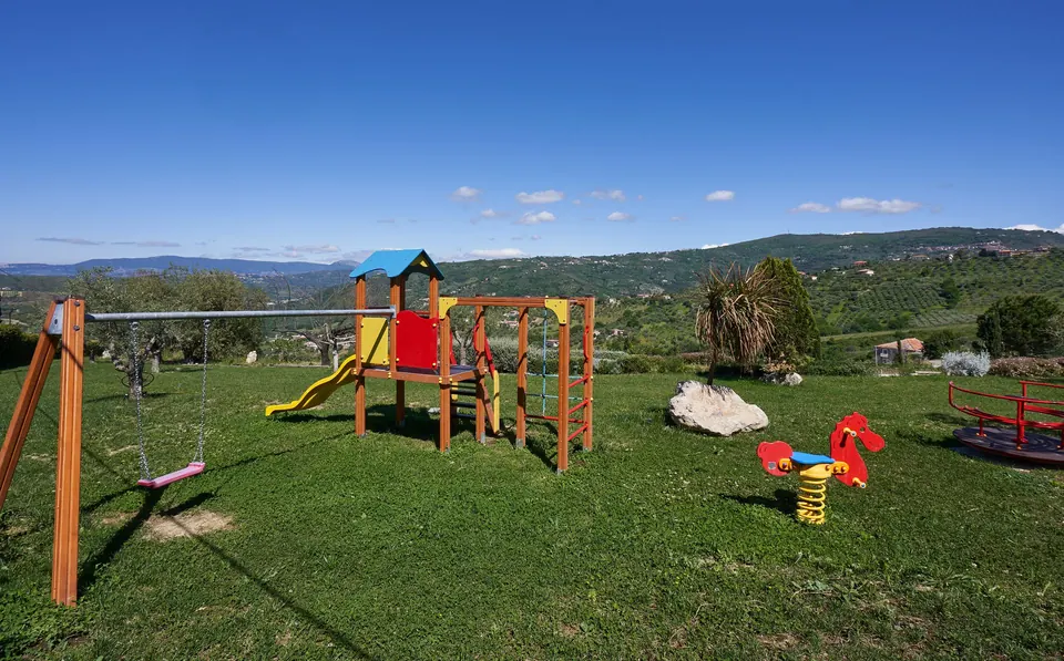 Area giochi per bambini sul prato tra gli ulivi